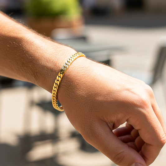 Mano de una modelo usando una pulsera cubana martillada en oro amarillo con cristal de Joyería Caracas.