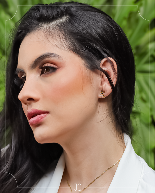 Oreja de mujer con topito en forma de cruz lisa en oro amarillo de 18 quilates, hechos en Joyería Caracas.