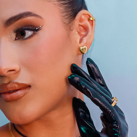 Oreja de mujer usando topito en forma de corazón XL en oro amarillo de 18 quilates de Joyería Caracas.