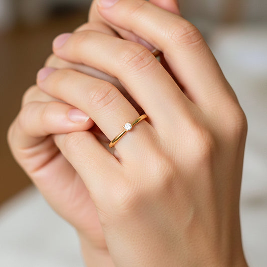 Mano de modelo usando un anillo solitario en oro amarillo de 18 quilates con cristal de Joyería Caracas.
