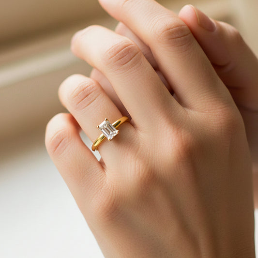 Mano de modelo usando un anillo en oro amarillo de 18 quilates con cristal en corte baguette de Joyería Caracas.