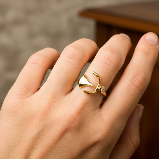 Mano de mujer usando un anillo con la forma de bicicleta en oro amarillo de 18 quilates con cristal de color blanco de Joyería Caracas.