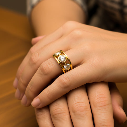 Mano de mujer usando un anillo en oro amarillo de 18 quilates con 3 cristales de color blanco redondos de Joyería Caracas.