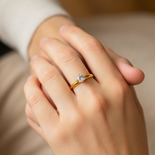 Mano de modelo usando un anillo solitario en oro amarillo de 18 quilates con cristal de Joyería Caracas.