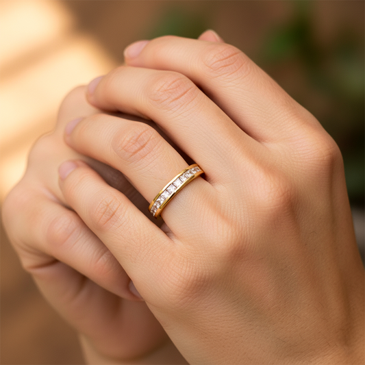 Mano de mujer usando un anillo en oro amarillo de 18 quilates con cristales cuadrados de color blanco de Joyería Caracas.