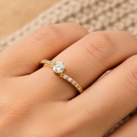 Mano de mujer usando un anillo diseño deep navy en oro amarillo de 18 quilates con moissanites de color blanco de Joyería Caracas.