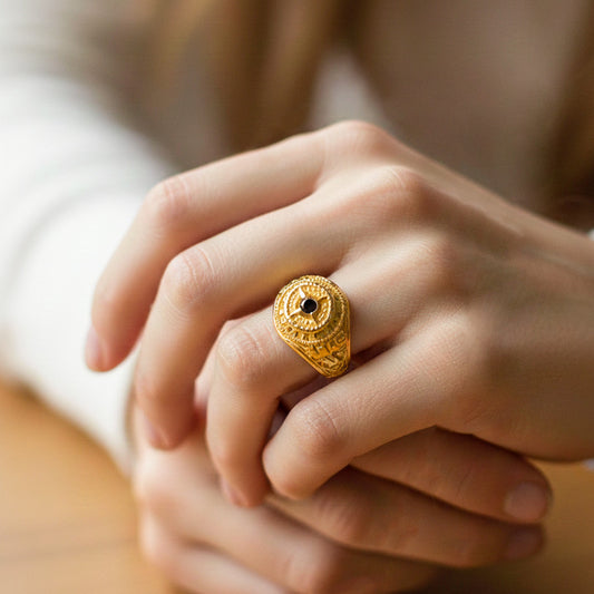 Mano de modelo usando un anillo de grado en oro amarillo de 18 quilates con cristal negro de Joyería Caracas.