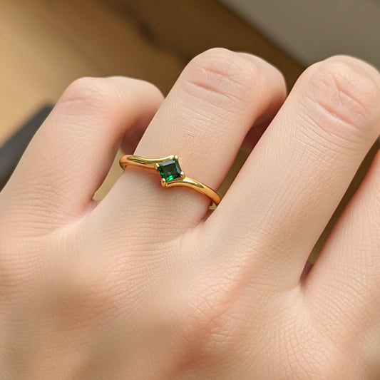 Mano de modelo usando un anillo en oro amarillo de 18 quilates con Esmeralda cuadrada de Joyería Caracas.