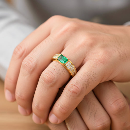 Mano de hombre usando un anillo en oro amarillo de 18 quilates con Esmeralda en corte baguette con cristales blancos de Joyería Caracas.