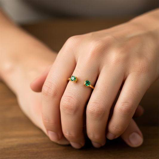 Mano de mujer usando un anillo en oro amarillo de 18 quilates con Esmeraldas de Joyería Caracas.
