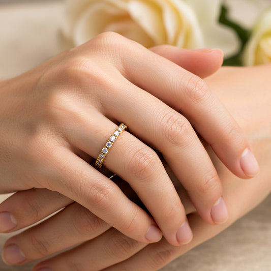 Mano de mujer usando un anillo sin fin en oro amarillo de 18 quilates con Diamantes alrededor de color blanco de Joyería Caracas.