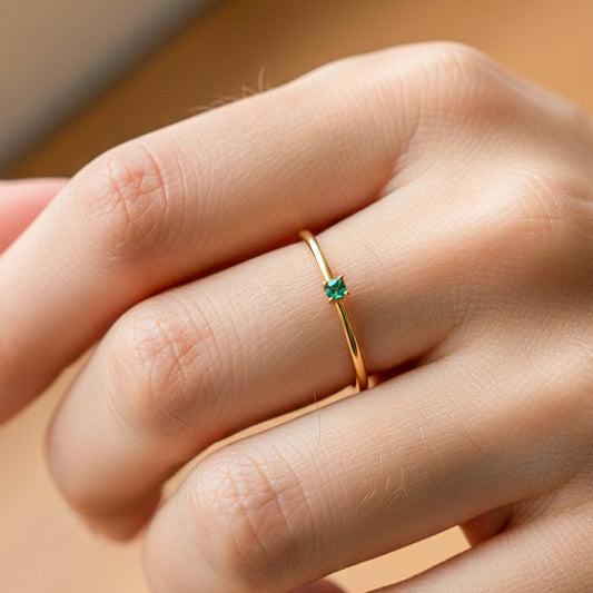 Mano de modelo usando un anillo en oro amarillo de 18 quilates con Esmeralda de Joyería Caracas.