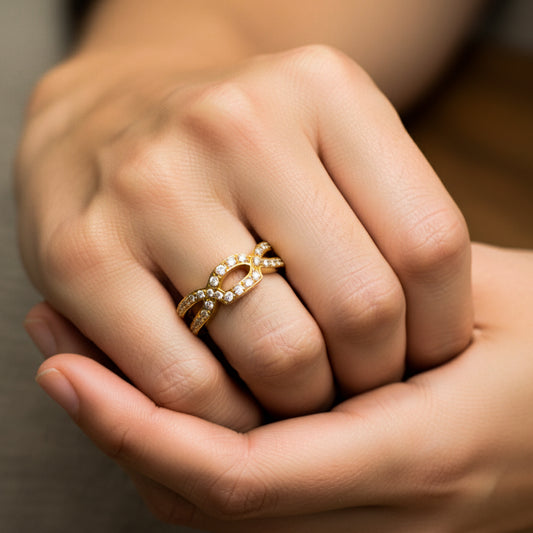 Mano de mujer usando un anillo en oro amarillo de 18 quilates con cristales de color blanco de Joyería Caracas.