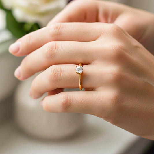 Mano de modelo usando un anillo en oro amarillo de 18 quilates con cristal blanco de Joyería Caracas.