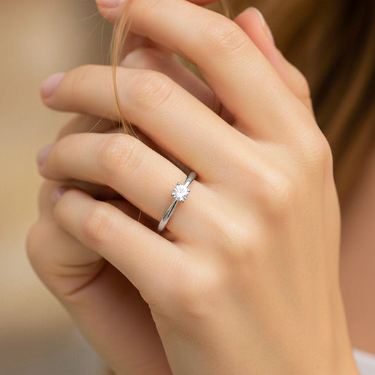 Mano de modelo usando un anillo solitario en oro blanco de 18 quilates con cristal de Joyería Caracas.