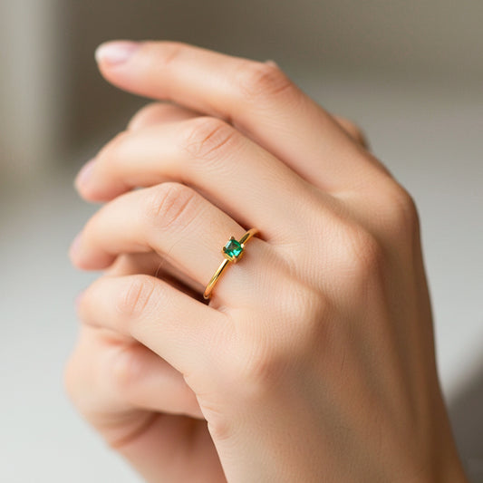 Mano de modelo usando un anillo en oro amarillo de 18 quilates con Esmeralda de Joyería Caracas.