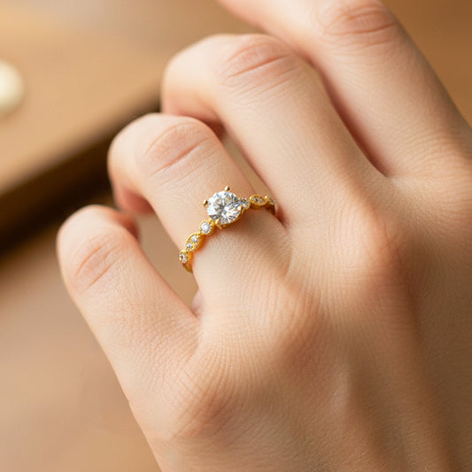 Mano de modelo usando un anillo solitario en oro amarillo de 18 quilates con cristales de Joyería Caracas.