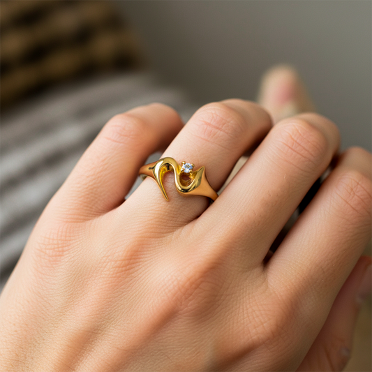 Mano de mujer usando un anillo en oro amarillo de 18 quilates con cristal de color blanco de Joyería Caracas.