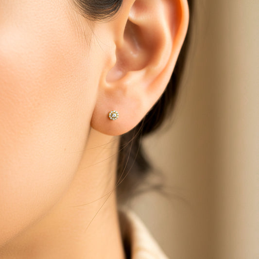 Oreja de modelo usando un arete circular en oro amarillo de 18 quilates con cristales de color blanco de Joyería Caracas.