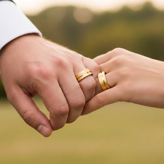 Manos de una pareja usando unas argollas de matrimonio en oro amarillo de 18 quilates de Joyería Caracas.