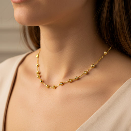 Cuello de mujer usando una gargantilla denario con esferas diamantadas en oro amarillo de 18 quilates de 45cm de Joyería Caracas.