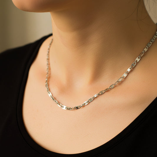 Cuello de mujer usando una cadena en tejido escalera plana en oro blanco de 18 quilates de Joyería Caracas.