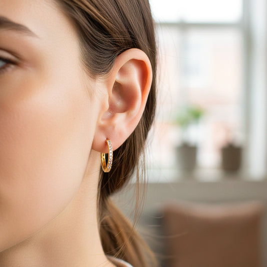 Oreja de modelo usando unas candongas en oro amarillo de 18 quilates con piedras de Joyería Caracas.