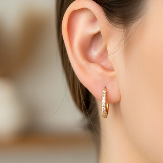 Oreja de modelo usando unas candongas en oro amarillo de 18 quilates con cristales de Joyería Caracas.