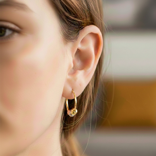 Oreja de modelo usando unas candongas cuadradas con esferas diamantadas en 3 oros de 18 quilates de Joyería Caracas.