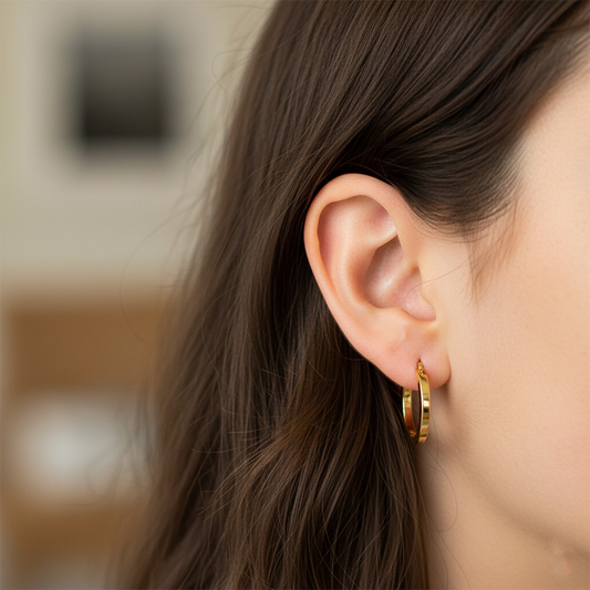 Oreja de modelo usando unas candongas en oro amarillo de 18 quilates de Joyería Caracas.