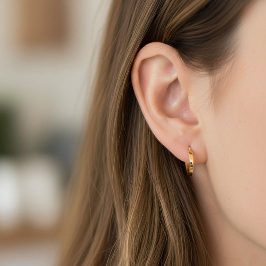 Oreja de modelo usando unas candongas en oro amarillo de 18 quilates de Joyería Caracas.