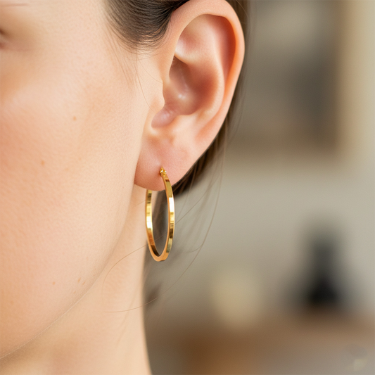 Oreja de modelo usando unas candongas en oro amarillo de 18 quilates de Joyería Caracas.