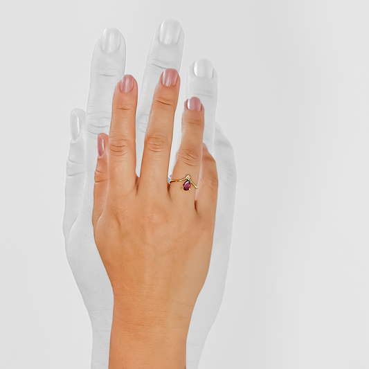 Mano de mujer con anillo en oro amarillo de 18 quilates con piedra Granate y Diamante de color blanco, hecho en Joyería Caracas.