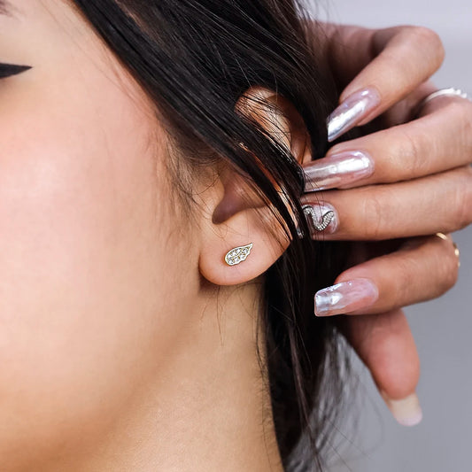 Oreja con topito en forma de alas en oro amarillo de 18k con cristales blancos hechos en Joyería Caracas.