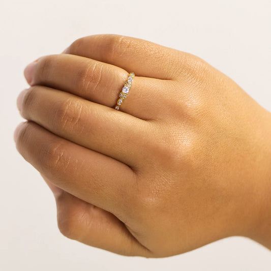 Mano de mujer con anillo en oro amarillo de 18 quilates con cristales de color blanco, hecho en Joyería Caracas.