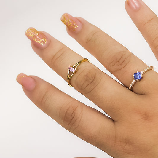 Mano de mujer usando un anillo de compromiso en oro amarillo de 18 quilates con piedra en el centro en forma de baguette de Joyería Caracas.