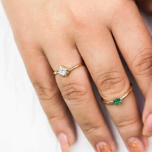 Mano de mujer usando un anillo en oro amarillo de 18 quilates con cristal en forma cuadrada de color blanco en el centro de Joyería Caracas.