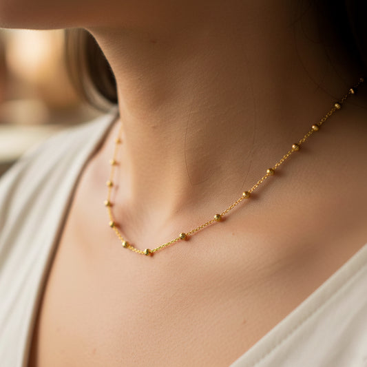 Cuello de mujer usando una gargantilla de esferas facetadas en oro amarillo de 18 quilates de Joyería Caracas.