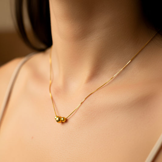 Cuello de mujer usando una gargantilla veneciana en oro amarillo de 18 quilates de 3 esferas lisas de Joyería Caracas.