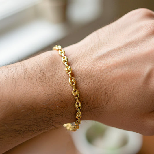 Mano de hombre usando una pulsera tejido calabrote en oro amarillo de 18 quilates de Joyería Caracas.