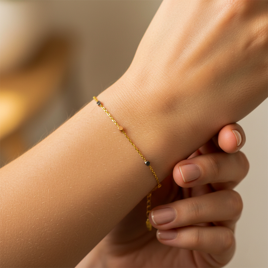 Mano de mujer usando una pulsera con formas de cuadrados - dados en 3 oros de 18 quilates de Joyería Caracas.