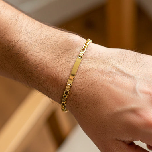 Mano de hombre usando una pulsera con esclava en tejido cubano 3x1 en oro amarillo de 18 quilates de Joyería Caracas.