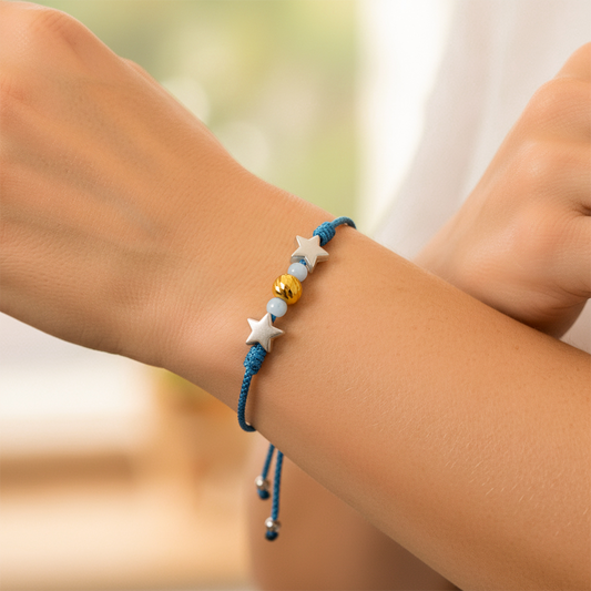 Mano de modelo usando una pulsera tejida en hilo color azul, esfera facetada y bisutería de calidad de Joyería Caracas.