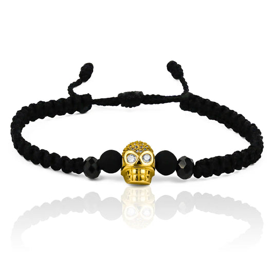 Pulsera Calavera de Joyería Caracas está elaborada en oro 18k, con detalles en hilo terlenca y bisutería de calidad. Con garantía de por vida y sin costo adicional.