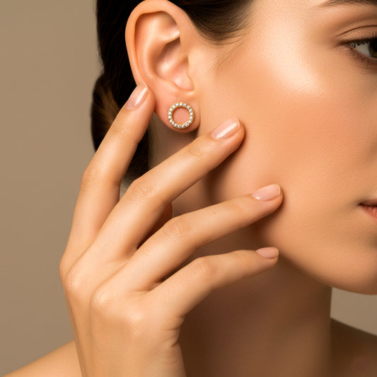 Oreja de modelo usando un topito en forma de círculo en oro amarillo de 18 quilates en oro amarillo de 18 quilates con cristales de color blanco de Joyería Caracas.