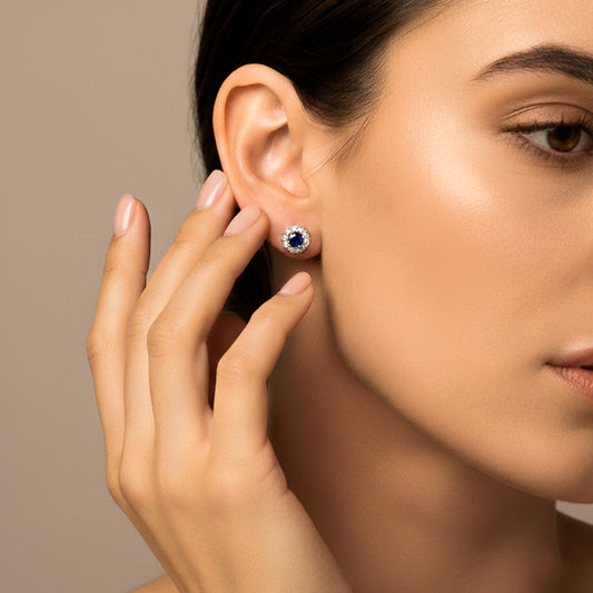 Oreja de modelo usando un topito en forma de dona en oro blanco de 18 quilates con Zafiro en el centro y Diamantes alrededor de Joyería Caracas.