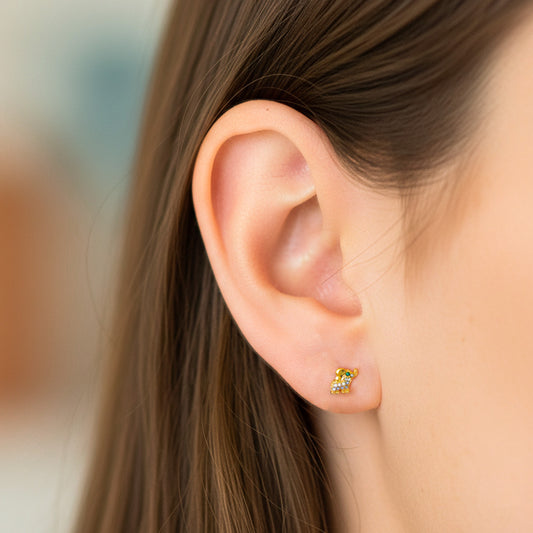 Oreja de modelo usando un topito en forma de elefante en oro amarillo de 18 quilates con cristales de Joyería Caracas.