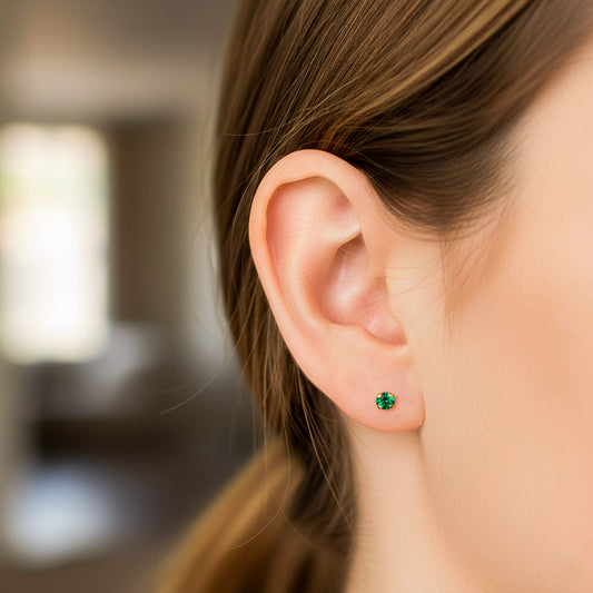 Oreja de modelo usando un topito en oro amarillo de 18 quilates con Esmeralda de 2,75mm de Joyería Caracas.