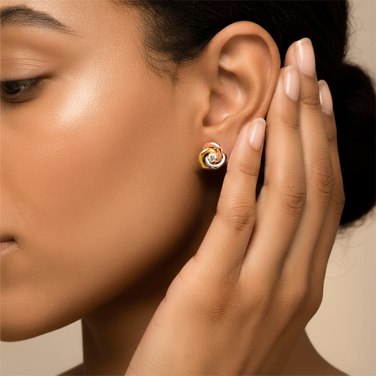 Oreja de modelo usando un topito en forma de espiral 3 oros de 18 quilates con cristal de color blanco de Joyería Caracas.