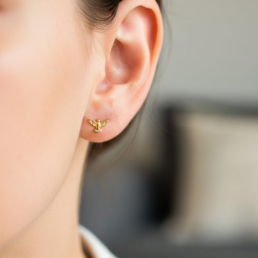 Oreja de modelo usando un topito en forma del Espíritu Santo en oro amarillo de 18 quilates de Joyería Caracas.